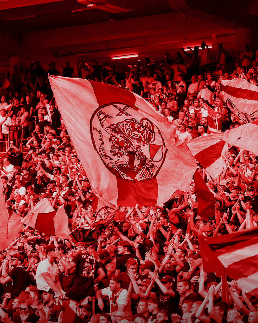 Ajax supporters met vlaggen op de tribune